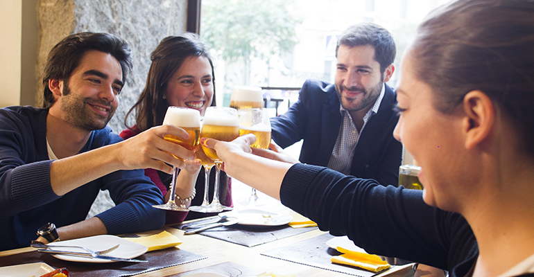 Grupo de amigos consumiendo cerveza en un bar