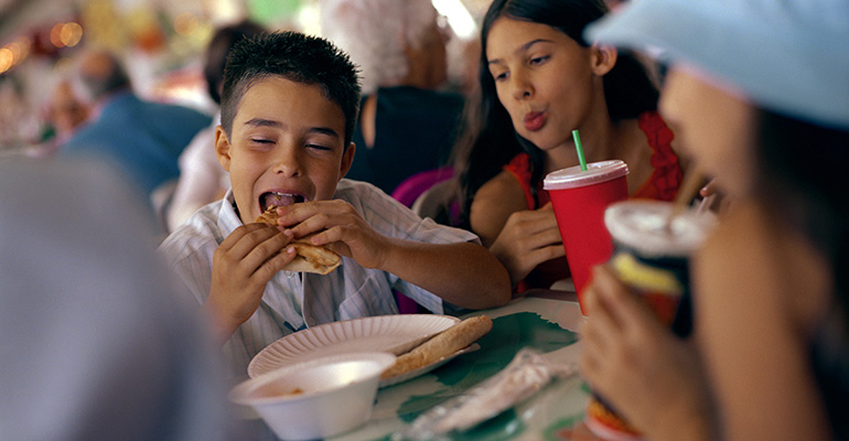 Jóvenes comiendo en establecimiento de comida rápida